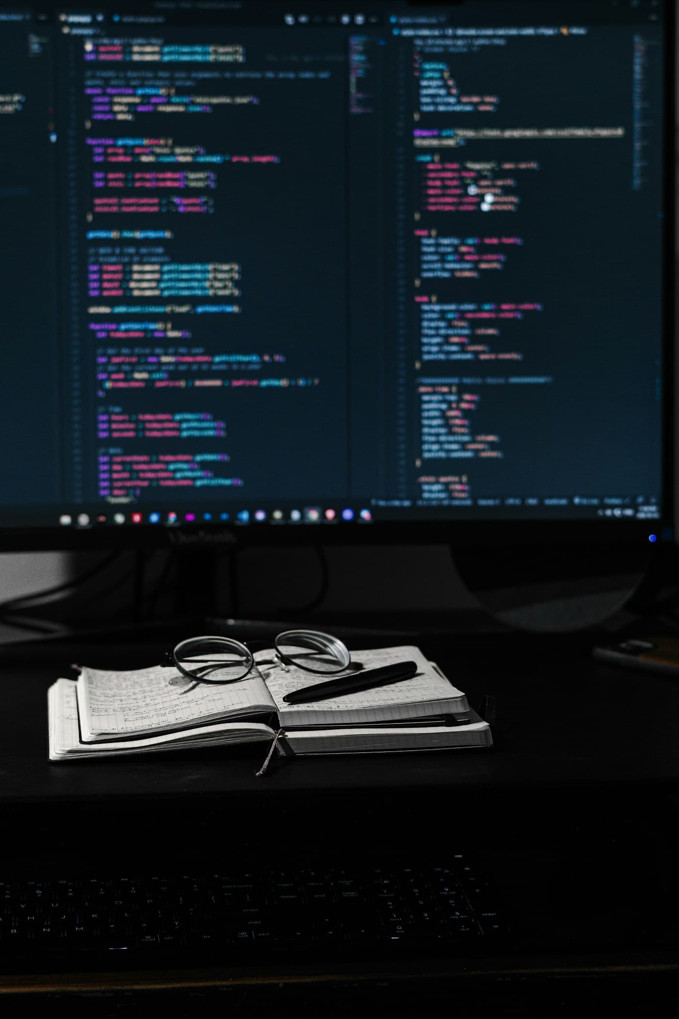 Developer working at a laptop in a dim workspace